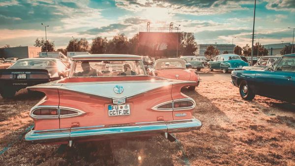 Rückseite eines klassischen US-Car-Oldtimer. Im Hintergrund ist die Leinwand des Autokino zu sehen.