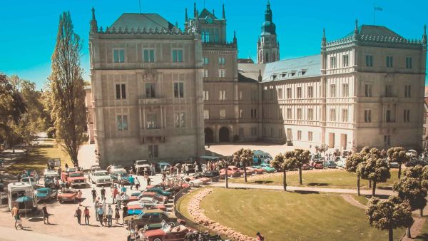 Oldtimer und Youngtimer stehen aufgereiht vor der Ehrenburg in Coburg beim Oldtimertreffen