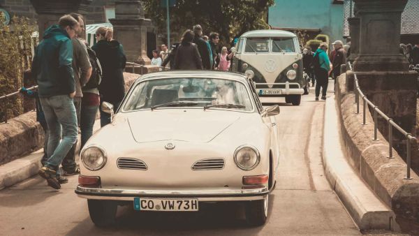Oldtimer-VW und VW-Bully Bus fahren über die Brücke in Frickendorf