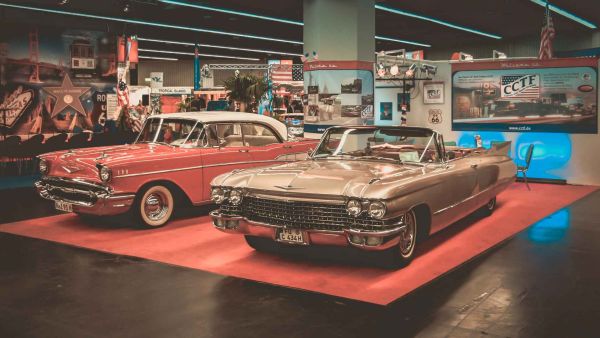 Links ein roter Chevrolet BelAir und rechts ein Cadilliac Convertible auf dem CCTF Messestand der Freizeit und Touristik